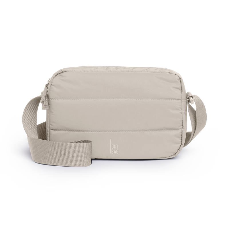 PUFFER CROSSBODY BAG bag in scallop (Light Beige), studio shot, front view.